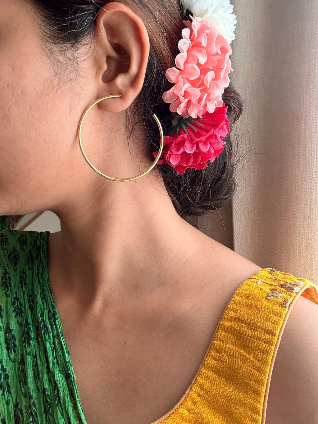 Side profile of woman wearing Sama Hoops as plain hoop without disc, green saree, pink flowers tucked in hair, showing the minimal wear option