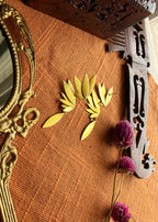 Front and Back view of Overhead flatlay of Apsara danglers on terracotta linen with antique hand mirror, wooden carved box, and dried purple flowers, warm natural light