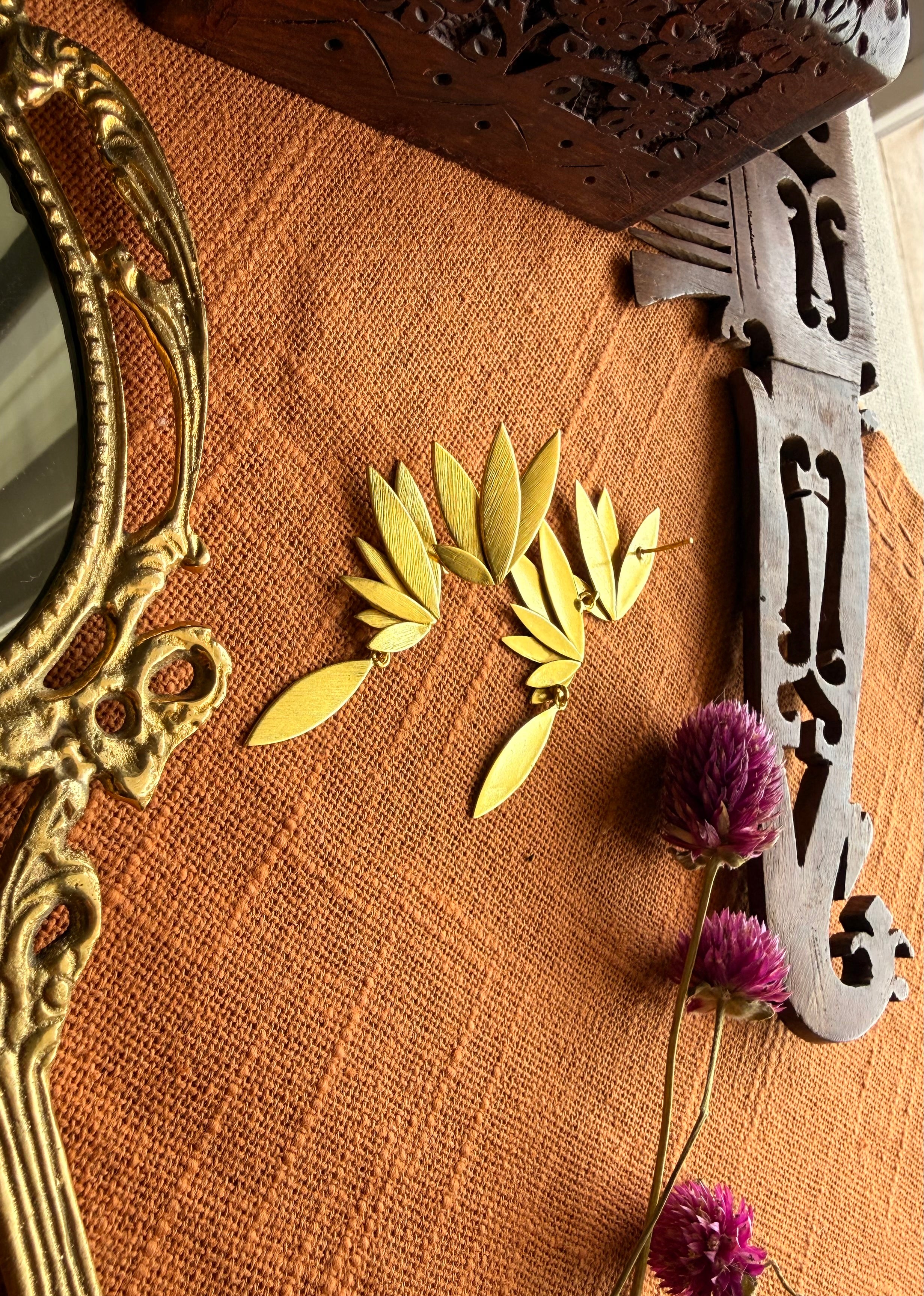 Front and Back view of Overhead flatlay of Apsara danglers on terracotta linen with antique hand mirror, wooden carved box, and dried purple flowers, warm natural light