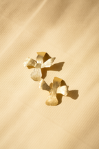 Beautiful Floral shaped, komal floret earrings kept on beige surface.