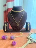 Full Motiya Capsule Collection displayed together — Motiya Choker and Lily Necklace layered on a dark velvet bust, Motiya Danglers on small velvet stands on either side, Motiya Lily Ring in the foreground, surrounded by dried purple globe amaranth flowers and a vintage brass mirror on terracotta linen.