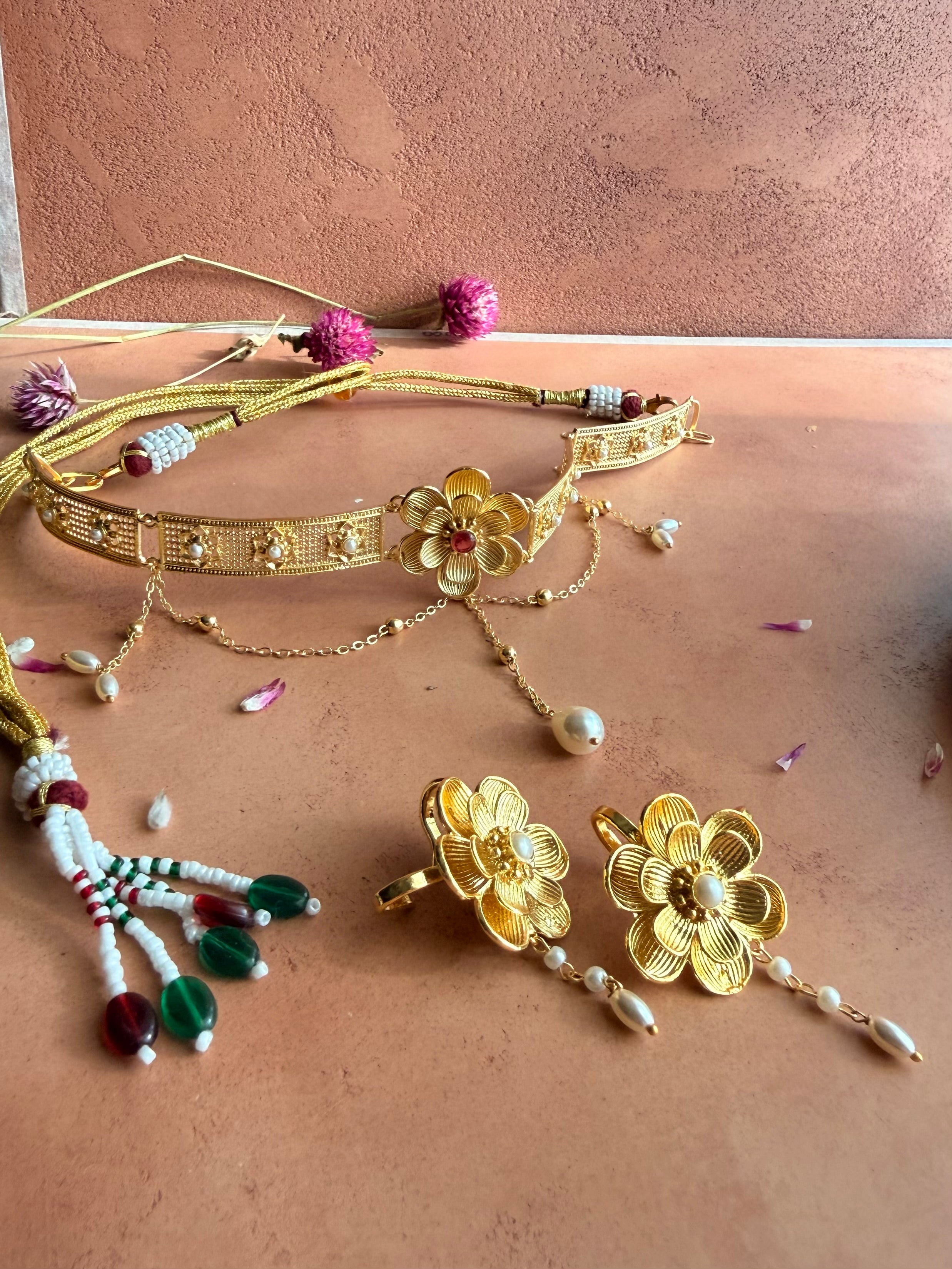 Nargis Choker flatlay on terracotta surface paired with matching Nargis earrings, gold filigree and pearl details visible, dried flowers scattered around