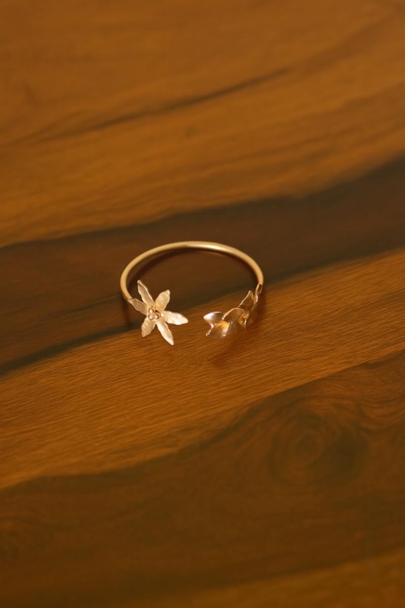 Gold plated cuff bracelet with floral designs on a brown surface
