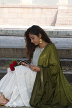 Woman holding a poetry book with red roses against a neutral background, wearing dangling gold earrings that catching the sunlight.