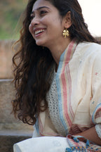 Woman in a traditional outfit with a blurred background wearing shubh earrings.