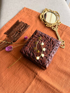 Sitara ear cuffs flatlay on terracotta fabric alongside a carved wooden box, antique hand mirror, and dried purple Globe Amaranth flowers, warm natural light