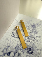 Gold earrings on a floral notebook page
