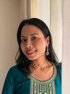 Woman in a teal embroidered kurta wearing the Valaya Necklace and Valaya Danglers, smiling